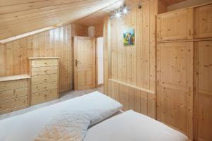 a bedroom with wooden walls and a bed in a room at Appartamento Primavera 3 in Moena