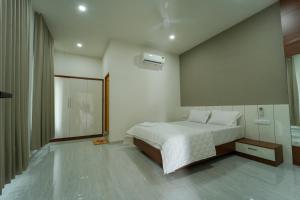 SK Premium Residency في Etakkare: غرفة نوم بسرير أبيض ونافذة كبيرة