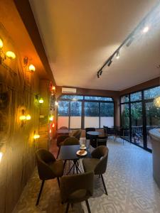 ティラナにあるGolden Flower Hotelのテーブルと椅子と窓のある部屋