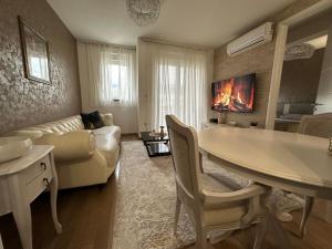 莫斯塔尔Apartman VIP的一间带桌子的客厅和一间带沙发的客厅