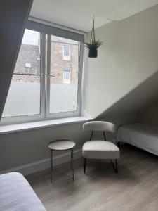 Park House Rooms - Sky TV and kitchenette في أبردين: غرفة نوم بها سرير وكرسي ونافذة