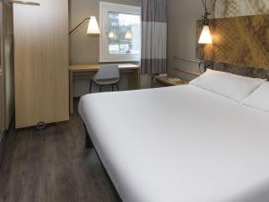 Una habitación de hotel con una cama grande y un escritorio. en ibis Tilburg, en Tilburg 81 fotos más