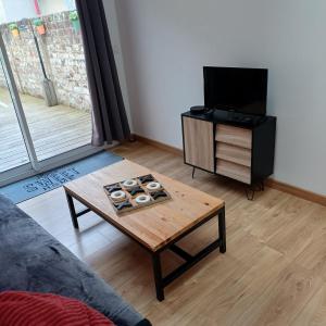 フェカンにあるLe petit cauchoisのコーヒーテーブルと薄型テレビのあるリビングルーム