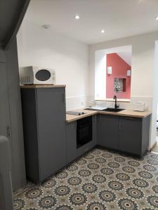 フェカンにあるLe petit cauchoisのシンクとカウンタートップのあるキッチン