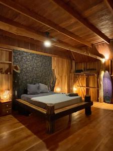Un dormitorio con una cama en una habitación con paredes de madera. en Finca Zayan, en El Copé