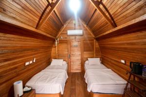 WainapalMulei bungalow Krui的木房里设有三张床的房间 更多3张照片