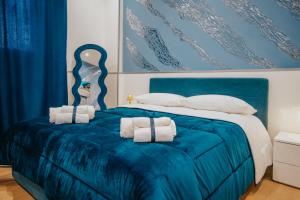 a bedroom with a blue bed with towels on it at Cama Luxury Rooms in Palermo +25 photos