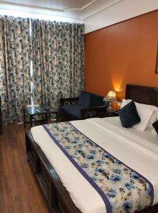um quarto de hotel com uma cama e um sofá em hotel Baljees Regency em Shimla mais 7 fotografias