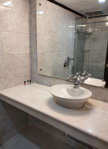 um banheiro com uma pia e um espelho em hotel Baljees Regency em Shimla