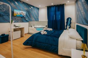 a bedroom with a blue and white bed and a tub at Cama Luxury Rooms in Palermo