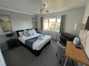 a bedroom with a bed and a desk and a chair at Glebeside House in Satley