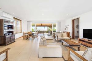 カップ・マルールーにあるVilla Satori - Sejour d'exception au bord de l'eauのリビングルーム(家具、テレビ付)
