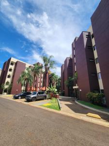 een straat met twee hoge gebouwen en palmbomen bij Apto 237 super bem localizado in Ribeirão Preto