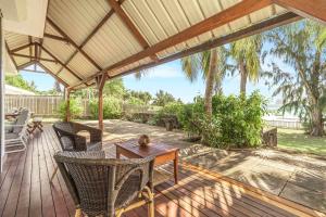 カップ・マルールーにあるVilla Satori - Sejour d'exception au bord de l'eauのデッキにテーブルと椅子が置かれたパティオ