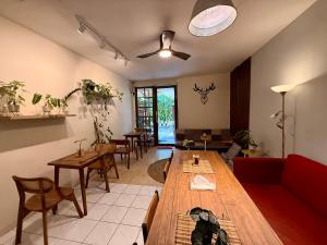 una sala de estar con una larga mesa de madera y sillas en Buton Backpacker Lodge, en Bandung