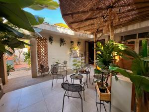 Un patio al aire libre con sillas, mesas y plantas. en Buton Backpacker Lodge, en Bandung