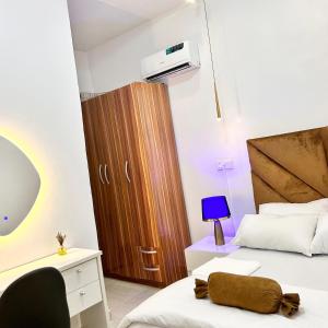 拉各斯Shortlet Apartment Ajah Lekki, Lagos的一间卧室，配有两张床和一个木柜 更多8张照片