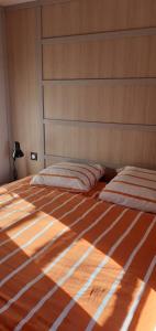 Una cama con dos almohadas encima en un dormitorio. en Chalet dans résidence privée avec piscine couverte, en Marzan