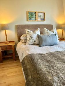 een slaapkamer met een groot bed met kussens erop bij BB BEACH BAY QUALITY APARTMENTs in Cape Town