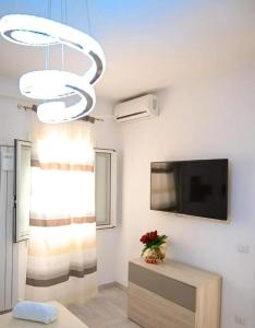 Eleven Home في باري: غرفة معيشة مع تلفزيون بشاشة مسطحة وثريا