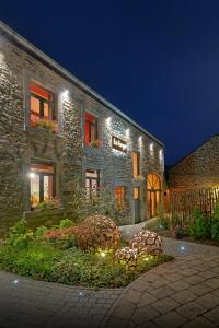 a stone house with lights in front of it at La Forge - Chambres d'hôtes en Ardenne in Wellin +42 photos