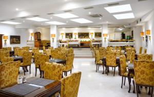 a restaurant with tables and chairs in a room at Hotel Leon D´Oro in Prague