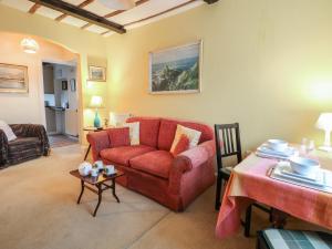 a living room with a red couch and a table at 6 Church Lane in Llanidloes