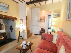 a living room with a red couch and a fireplace at 6 Church Lane in Llanidloes