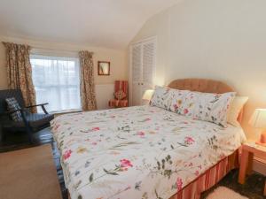 a bedroom with a bed with a floral bedspread at 6 Church Lane in Llanidloes