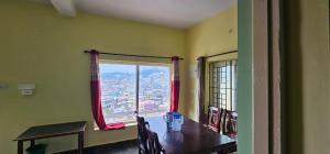 乌提OOTY STAY AWHILE的有桌子和窗户的餐厅