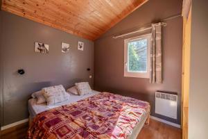 RoquefeuilChalet montana 2- 4pers的一间卧室，里面有一张床和一扇窗户。