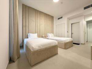 a bedroom with two beds in a room at Sahab - Masar 2BR Townhouse in Sharjah
