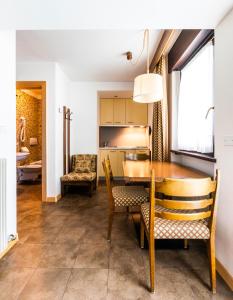 a kitchen and dining room with a table and chairs at Residence Lastei in San Martino di Castrozza