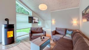 a living room with a couch and a fireplace at Avalon Ferienpark Bad Bevensen in Bad Bevensen