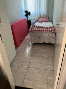 1 dormitorio pequeño con 1 cama y suelo de baldosa en Casa Girassol, en Ametista do Sul