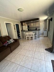 Una sala de estar y una cocina con un sofá y una mesa. en Casa Girassol, en Ametista do Sul