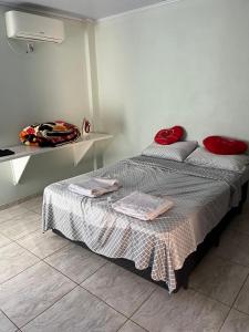 Un dormitorio con una cama con almohadas rojas. en Casa Girassol, en Ametista do Sul