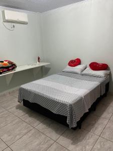 Un dormitorio con una cama con almohadas rojas. en Casa Girassol, en Ametista do Sul 7 fotos más