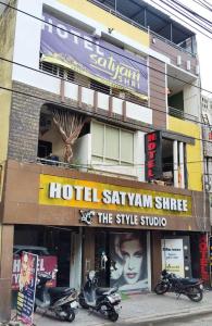 a hotel with scooters parked in front of a building at Hotal Satyam Shree in Jāmb