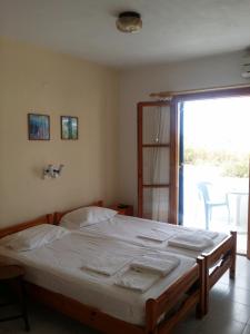 a bedroom with a bed and a sliding glass door at Esperides in Batsi