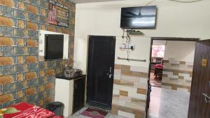 a room with a tv on a brick wall at Hotal Satyam Shree in Jāmb
