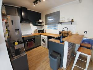 Una cocina con refrigerador y fregadero. en Ti Kaz Bananier, en Saint-Gilles-les Hauts 8 fotos más