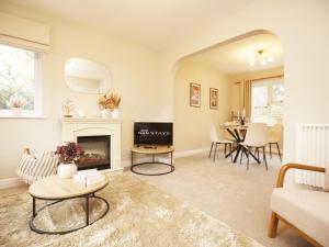 a living room with a fireplace and a table at Orchard Place Semington By N And N Stays, 20 Mins From Bath, Perfect for Contractors and Workers, Pvt Parking for 2 vehicles 