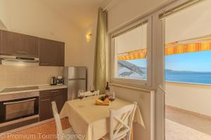 a kitchen with a table with wine glasses on it at Sladana direct at the beach in Metajna
