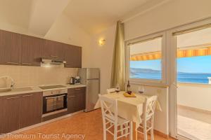 uma cozinha com uma mesa e vista para o oceano em Sladana direct at the beach em Metajna mais 86 fotografias