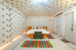 SPOT ON Dream Land Desert Camp في جيلسامر: غرفة صغيرة بها سرير وسجادة