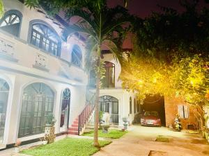 una casa con una palmera delante en Buono Villa, en Negombo