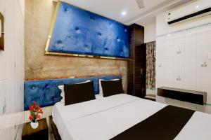 Un dormitorio con dos camas y una pared azul. en Collection O Chidambaram Stadium Formerly Hotel Admire Suit, en Chennai 24 fotos más