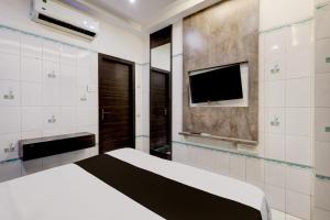 Un dormitorio con una cama y un televisor de pantalla plana. en Collection O Chidambaram Stadium Formerly Hotel Admire Suit, en Chennai