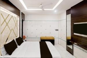 Un dormitorio con una cama y un televisor de pantalla plana. en Collection O Chidambaram Stadium Formerly Hotel Admire Suit, en Chennai